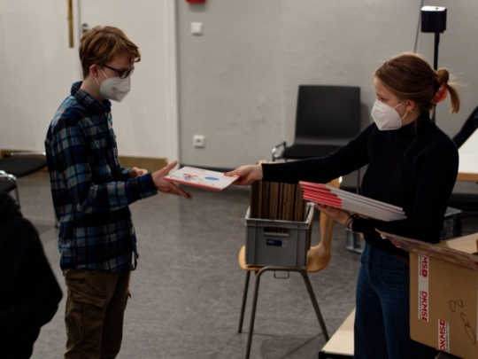 Greta verteilt die Registrierungssets