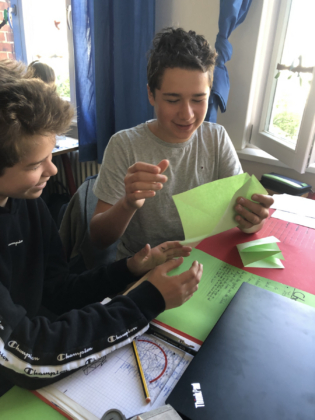 Mads, Leonard und Lucas probieren sich im Kranich-Falten