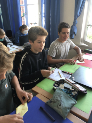 Mads, Leonard und Lucas probieren sich im Kranich-Falten